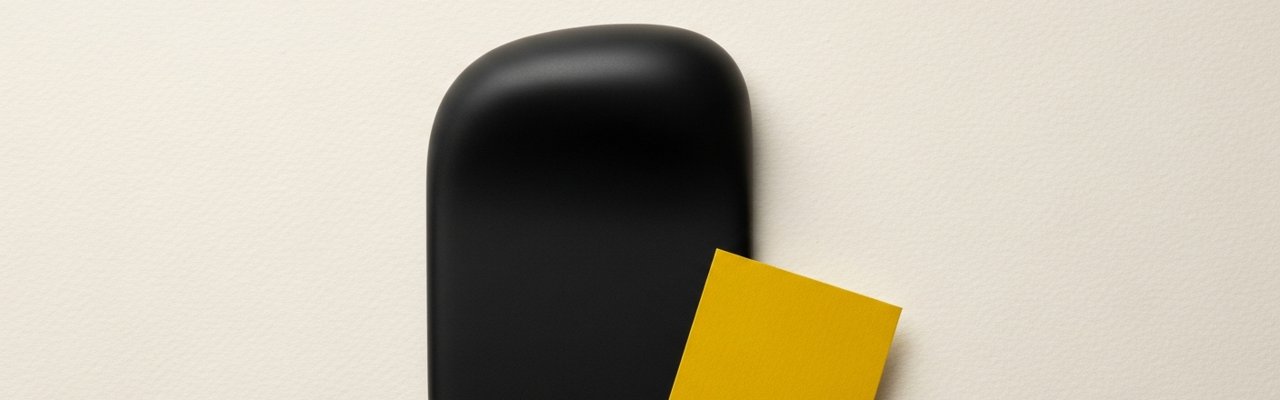 Black abstract object beside a yellow paper swatch on cream surface — ai ad agency pricing.