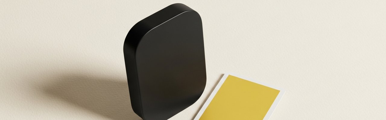 Black abstract object beside a yellow paper swatch on cream surface — meta advantage plus creative.