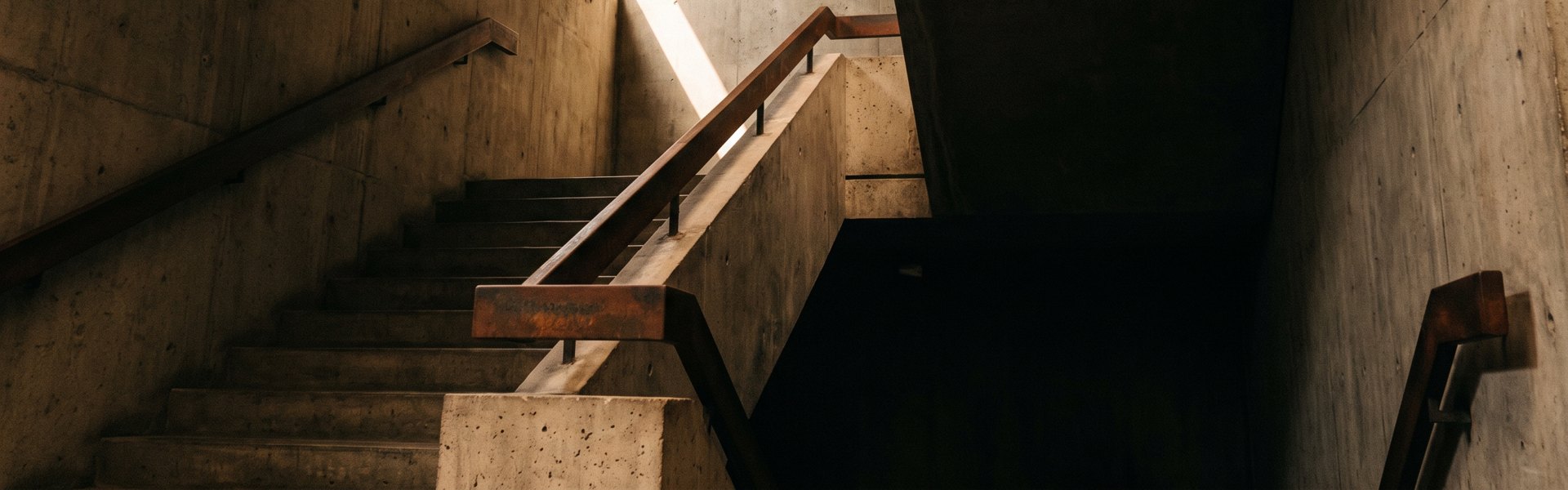 A single overhead light illuminates a sparse concrete room with one bare wooden chair centered in frame -- AI UGC Performance Equation framework.